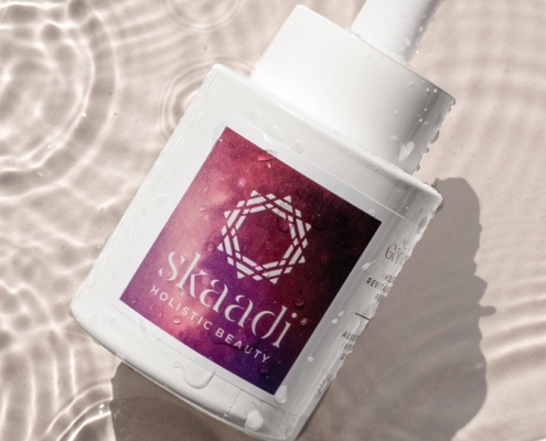 Göttertränen Elixier Pflegeöl Flasche auf beigem nassen Untergrund