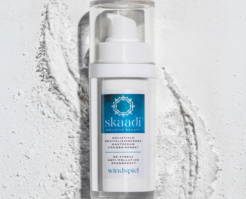 skaadi® Windspiel Elementra Herbstserum liegt auf weißem pudrigen Hintergrund