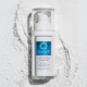skaadi® Windspiel Elementra Herbstserum liegt auf weißem pudrigen Hintergrund